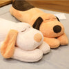 A large, light orange and white plush dog pillow doll lying on a gray surface.