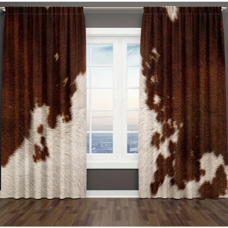 A pair of brown and white cow print curtains hanging in a window frame.