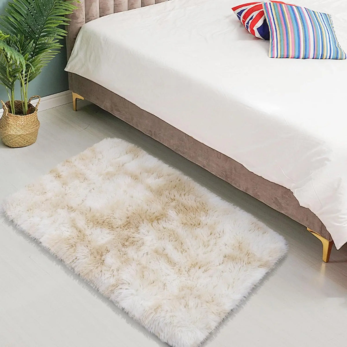 A fluffy cream silk wool area rug placed on a light wood floor next to a bed.