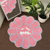 A pink and gray sunflower patterned absorbent non-slip bathroom mat on a wooden floor.