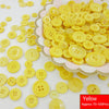 A pile of assorted yellow resin sewing buttons for crafting and DIY projects.