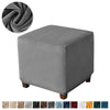 A square gray velvet ottoman slipcover shown next to a rolled fabric sample.