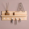 A wooden shelf holds a glass bottle and a metal rack of transparent round head push pins.