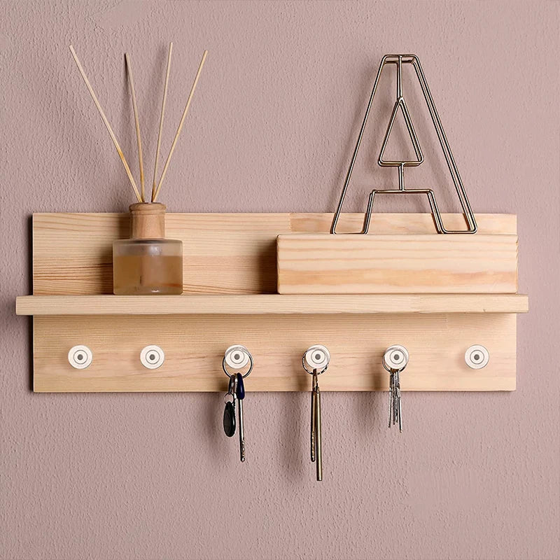 A wooden shelf holds a glass bottle and a metal rack of transparent round head push pins.