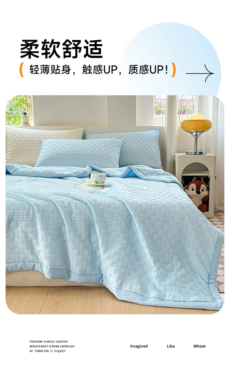 Light blue breathable waffle quilt spread on a bed with white pillows and a yellow lamp in the background.