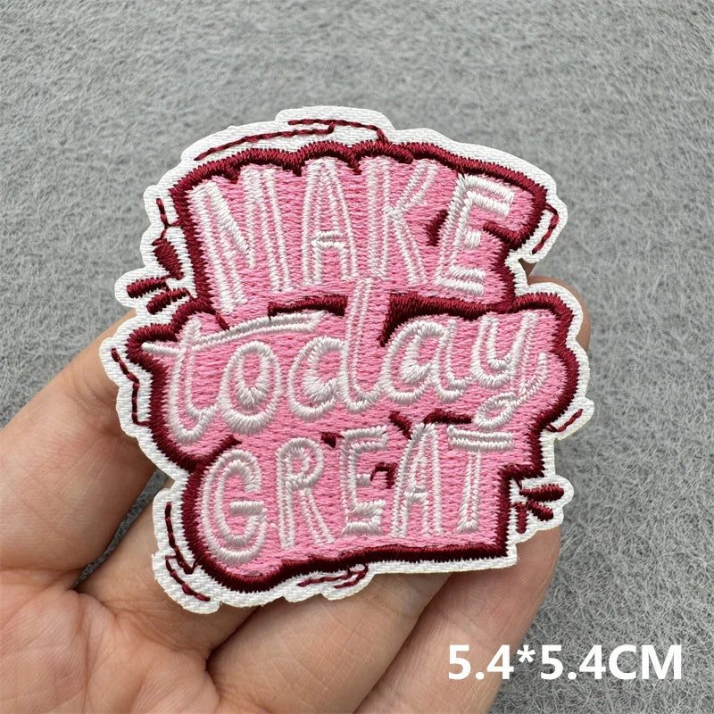 Pink embroidered patch with the text MAKE TODAY GREAT on a hand