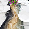 A rustic gauze table runner featuring shades of black, beige, and olive green draped across a white table setting.