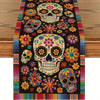 A colorful Day of the Dead table runner featuring skulls and floral patterns on a dark background.