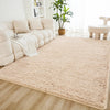 A cream tie-dye shaggy rug is placed on a light wood floor in a bright living room setting.