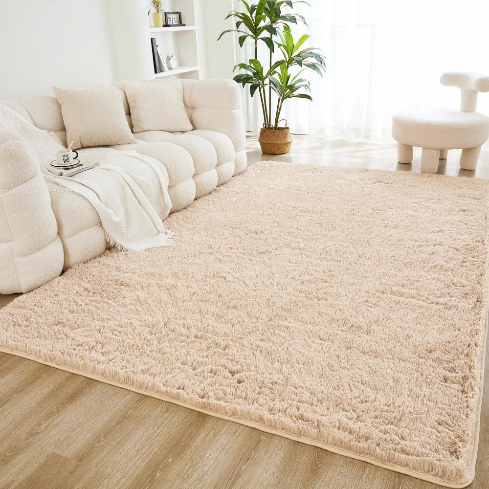 A cream tie-dye shaggy rug is placed on a light wood floor in a bright living room setting.
