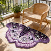 A purple irregular shaped plush floor rug with a detailed butterfly pattern rests on a light wooden floor.