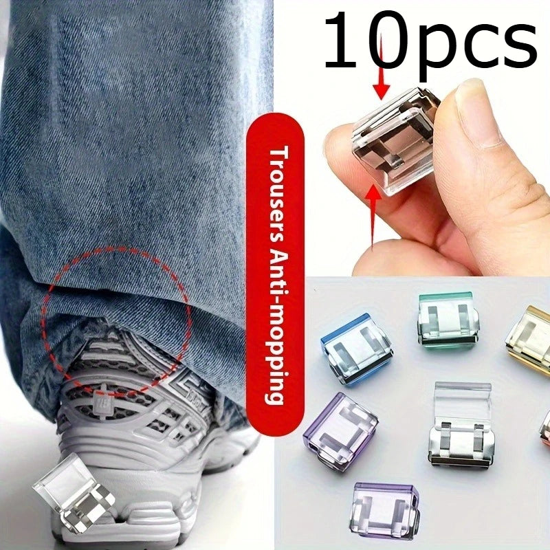 A hand holds several clear and translucent invisible hem shortening clips for clothing.