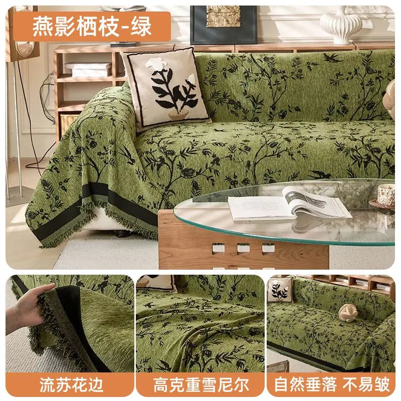 Green chenille sofa slipcover with black trim and floral pattern displayed on a wooden table.
