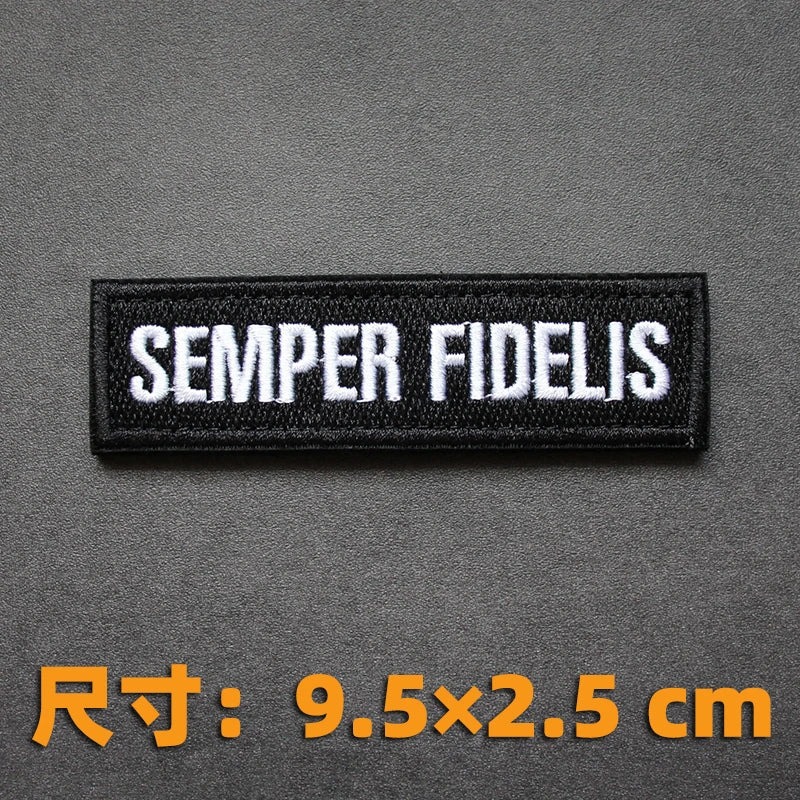 Black embroidered badge with the Latin phrase SEMPER FIDELIS on a dark gray background