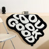 A black foot mat with white text spelling GOODUK is displayed on a light-colored surface.