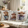 A decorative pillow cover featuring a print of a Highland cow's head with purple flowers.