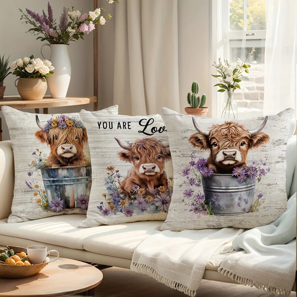 A decorative pillow cover featuring a print of a Highland cow's head with purple flowers.