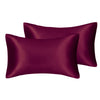 Two deep plum colored silky satin pillow covers, one folded over the other.