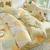 A beige and cream duvet and pillow set with geometric patterns on a bed.