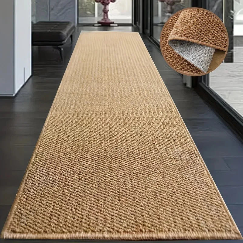 A long, rectangular natural sisal jute rug in a light tan color placed on a dark wood floor.