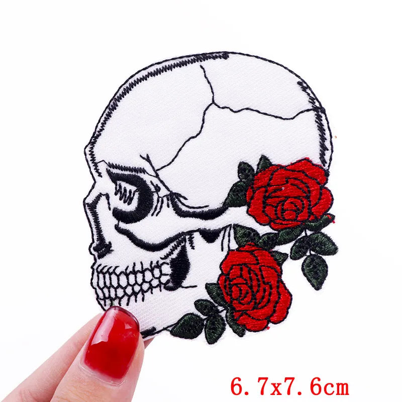 Embroidered skull iron-on patch featuring a detailed skull design with red roses on white fabric