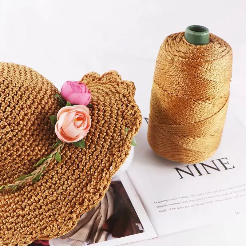 A golden brown crochet ice rope is shown next to a spool of the same material.