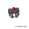 A pink embroidered letter patch featuring a straw hat woven into the design.