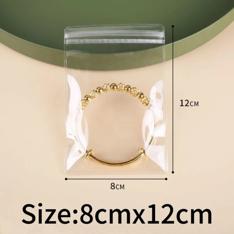 A clear plastic storage bag containing a gold-colored, beaded bracelet and earrings.