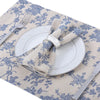 A checkered table runner featuring blue floral patterns and a napkin set with a silver ring.