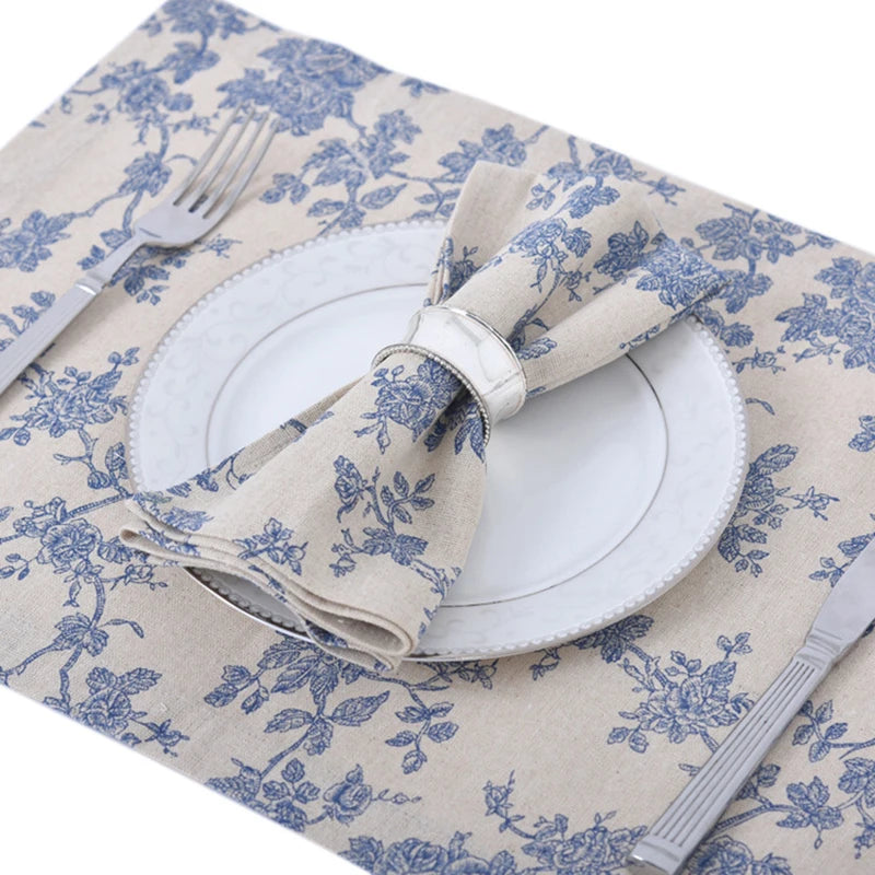 A checkered table runner featuring blue floral patterns and a napkin set with a silver ring.