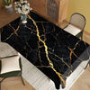 Black marble table cloth with gold veining placed on a wooden table.