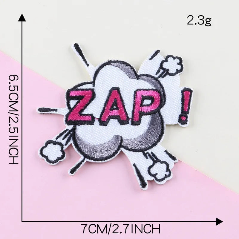 A white embroidery patch featuring the word ZAP in pink lettering inside a cloud shape with exclamation marks.