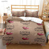 A brown duvet cover set with pink and black embroidered designs on the fabric, displayed on a bed.