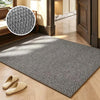 A rectangular gray faux sisal runner rug placed on a light wood floor with a pair of tan slippers nearby.