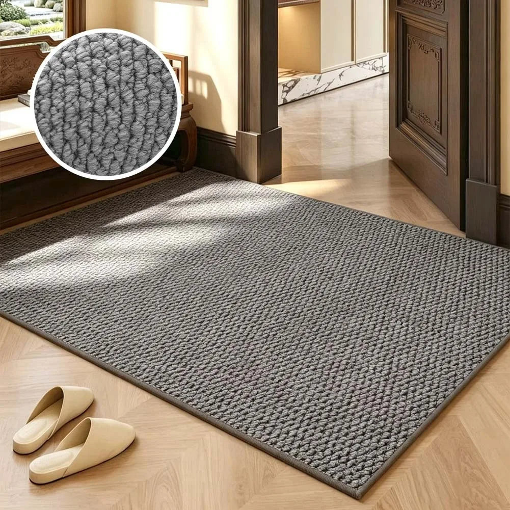 A rectangular gray faux sisal runner rug placed on a light wood floor with a pair of tan slippers nearby.