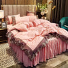 A pink bed with a lace edge skirt set featuring soft pink bedding and gold accents.