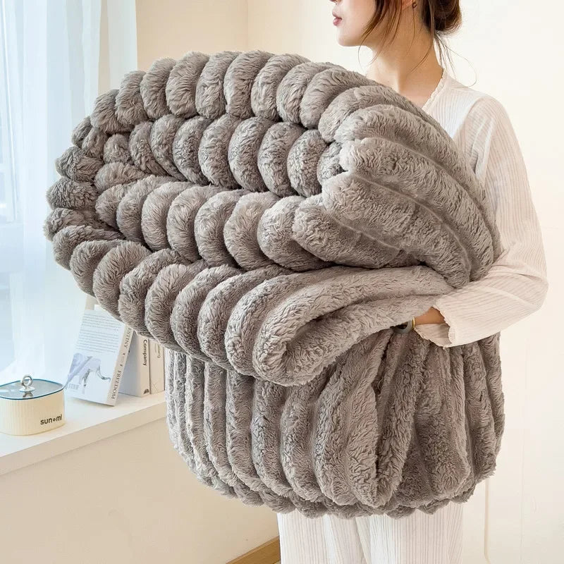 A fluffy gray faux fur blanket draped over a person's arm, showcasing its thick texture and cozy appearance.