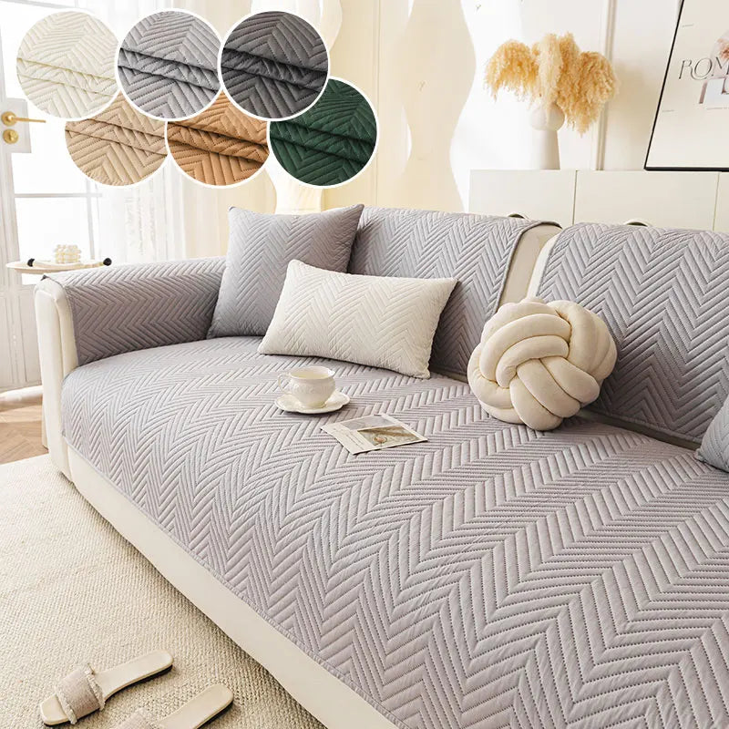 A light gray anti-slip fabric sofa cushion cover with a chevron pattern and decorative round fabric accents.