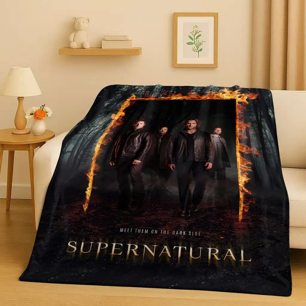 A dark themed blanket featuring characters from Supernatural with flames and the title on a black background