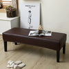 A dark brown waterproof stretch dining bench cover is displayed on a wooden bench in a bright room.