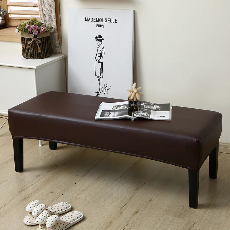 A dark brown waterproof stretch dining bench cover is displayed on a wooden bench in a bright room.