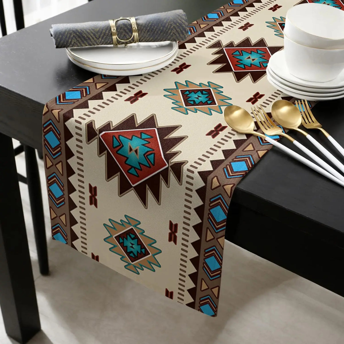 A bohemian linen table runner with an Indian-inspired geometric print is displayed on a dark table with gold cutlery.