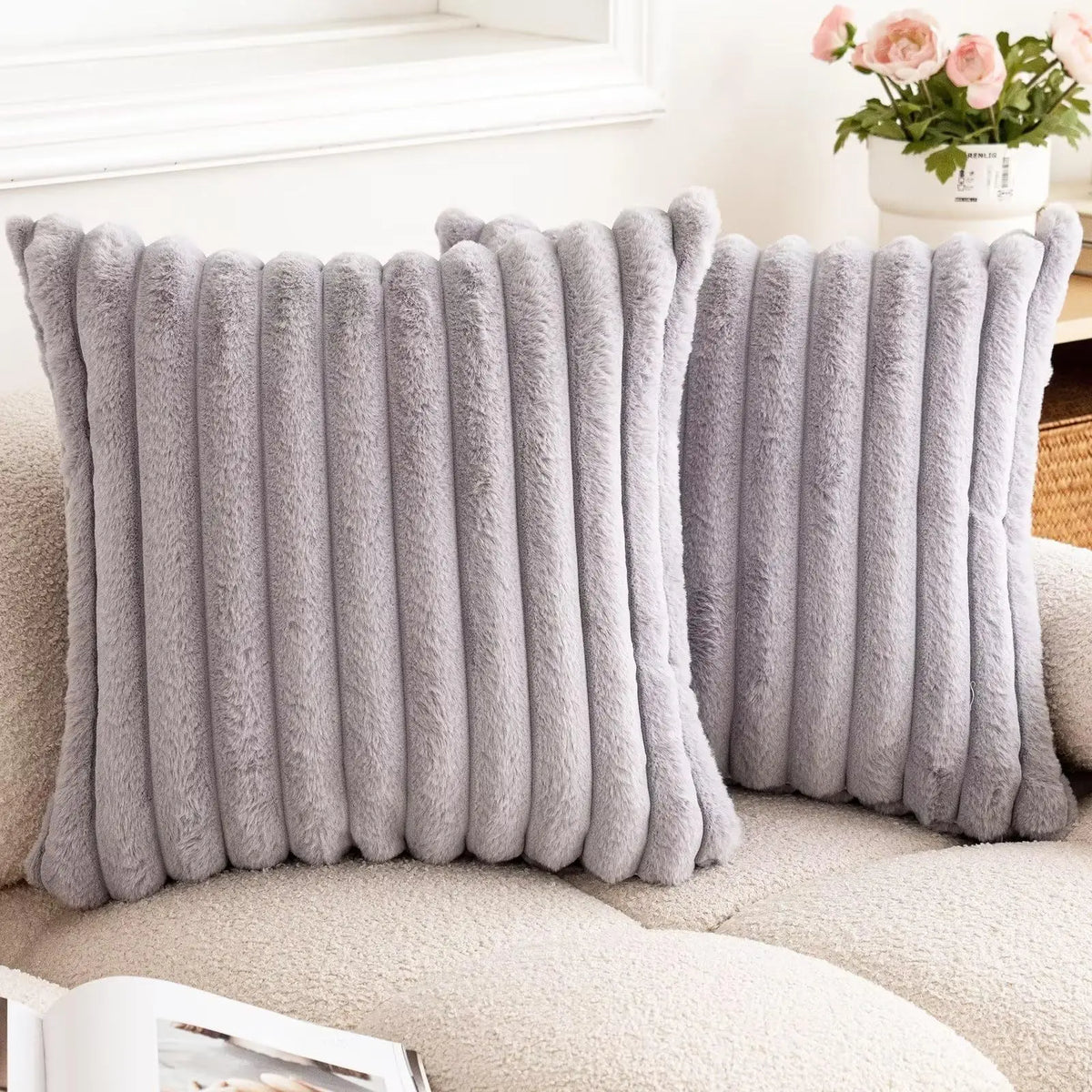 Gray square faux rabbit fur cushion cover displayed on a light-colored sofa.