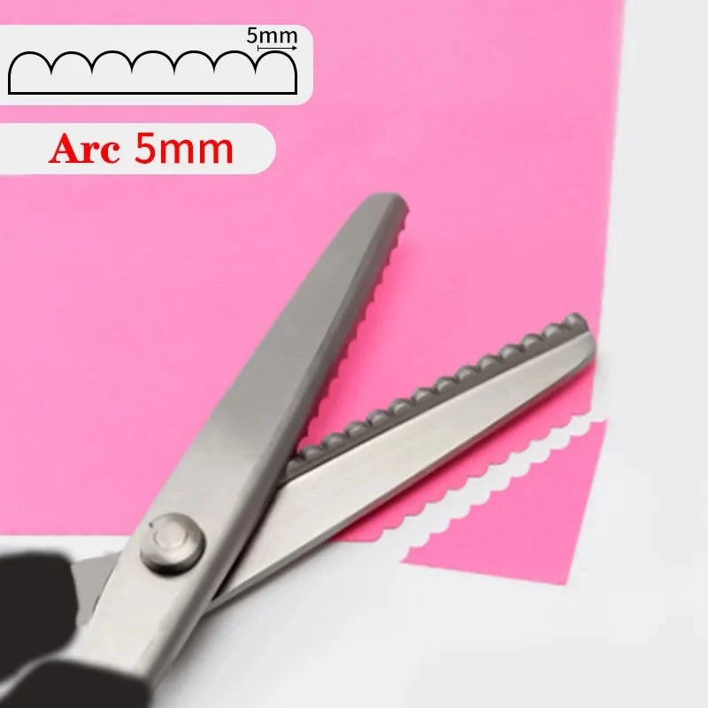 Stainless steel sewing scissors with a zig zag edge shown against pink paper.