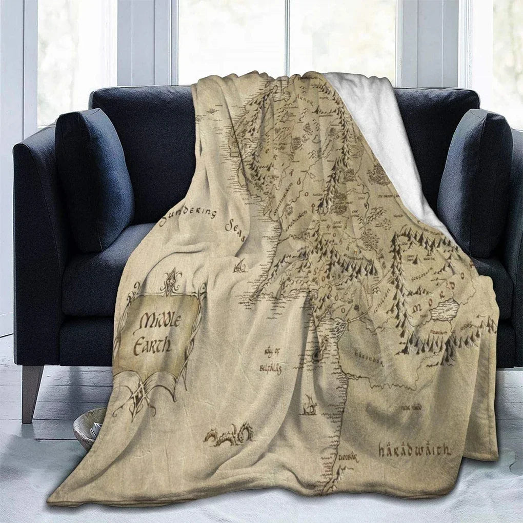 A beige blanket featuring a detailed map of Middle-earth, displayed on a dark sofa.