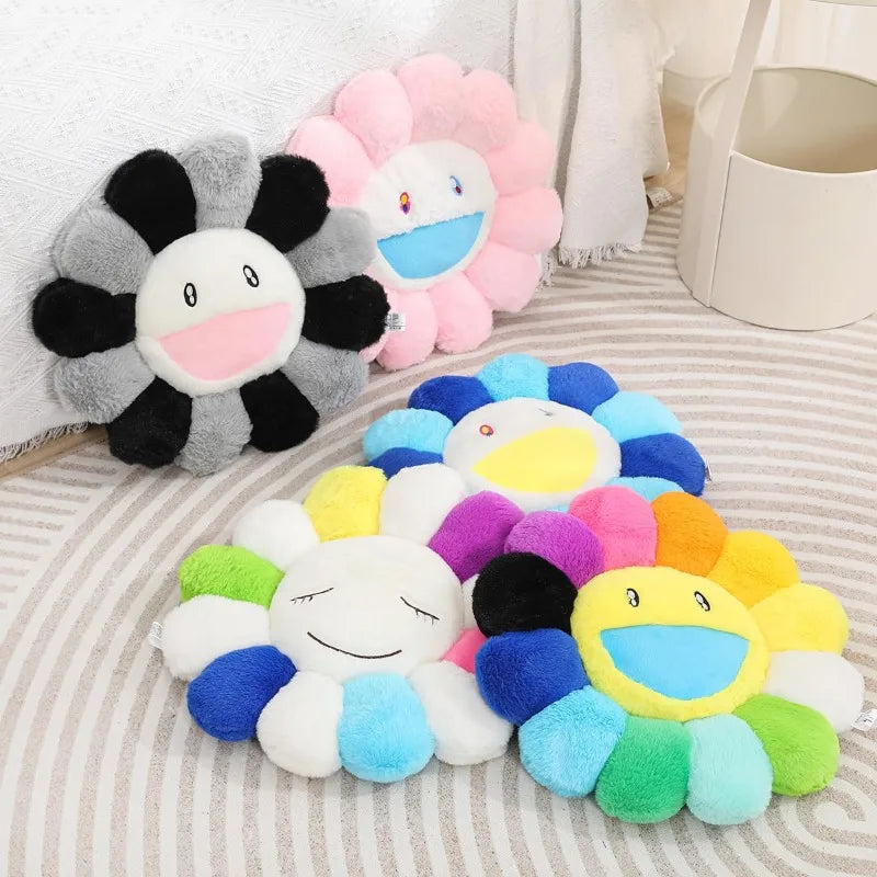 A collection of colorful sunflower plush cushions with smiling faces arranged on a light gray fabric.