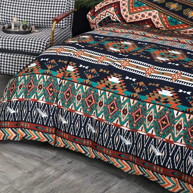 A close-up of a boho geometric duvet cover set featuring intricate patterns in teal, orange, brown, and navy on a bed.