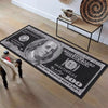 A long runner carpet featuring a 100 dollar bill design in black and white on a dark background.