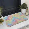 A colorful, fluffy silk wool area rug is displayed on a light gray floor in front of a dark door.