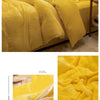 A set of luxurious yellow flannel duvet covers and pillows displayed on a bed.
